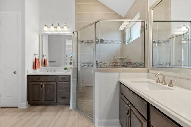5152 Cornetto Blfs, Round Rock, TX 78665 - bathroom with two vanities, a shower stall, wood finished floors, and vaulted ceiling