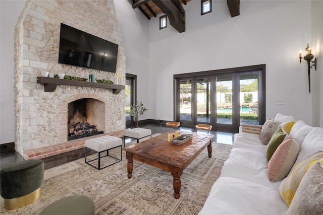 living room with beam ceiling, wood-type flooring, a fireplace, and high vaulted ceiling