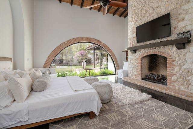 bedroom with high vaulted ceiling, beamed ceiling, a fireplace, wood ceiling, and hardwood / wood-style flooring