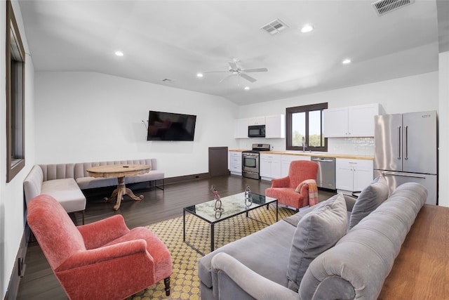 living room with ceiling fan, wood-type flooring, sink, and vaulted ceiling