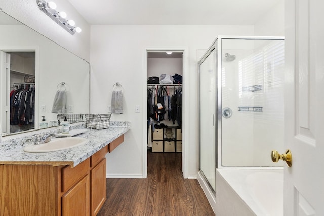 bathroom with hardwood / wood-style flooring, vanity, and separate shower and tub