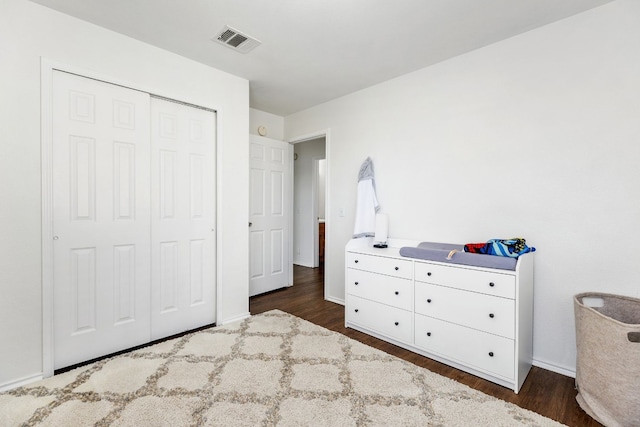 unfurnished bedroom featuring dark hardwood / wood-style flooring and a closet