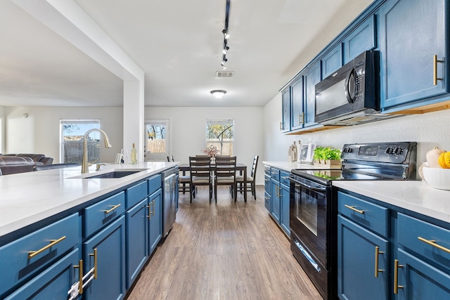 kitchen featuring blue cabinetry, sink, and black appliances