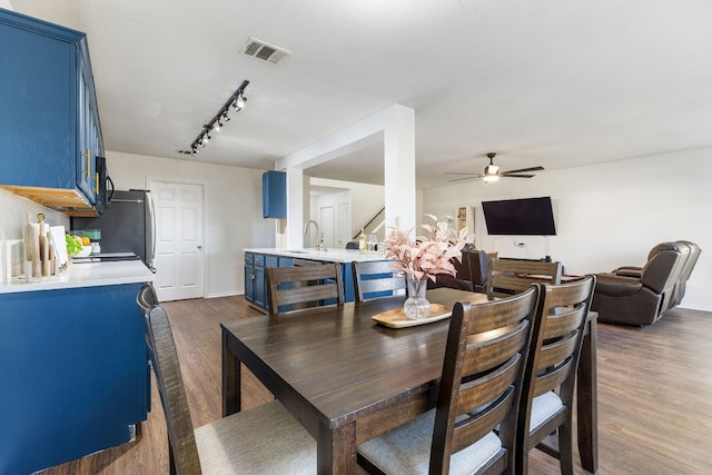 dining area featuring rail lighting, dark hardwood / wood-style floors, sink, and ceiling fan