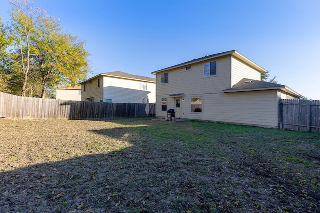 back of house with a lawn