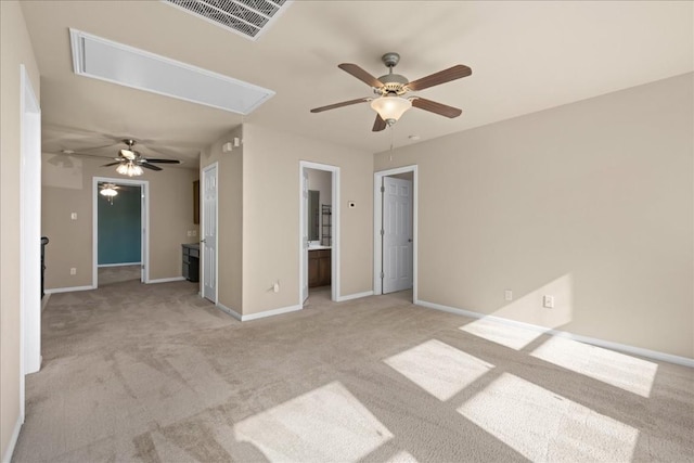 spare room with attic access, visible vents, baseboards, and light colored carpet