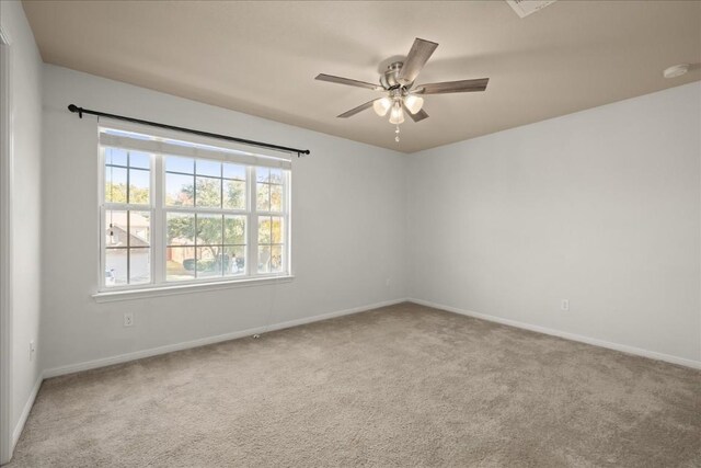 carpeted spare room with ceiling fan