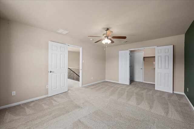 unfurnished bedroom featuring ceiling fan, a closet, and light colored carpet