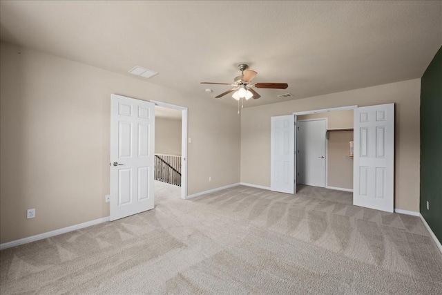 unfurnished bedroom featuring light colored carpet, a closet, visible vents, and baseboards