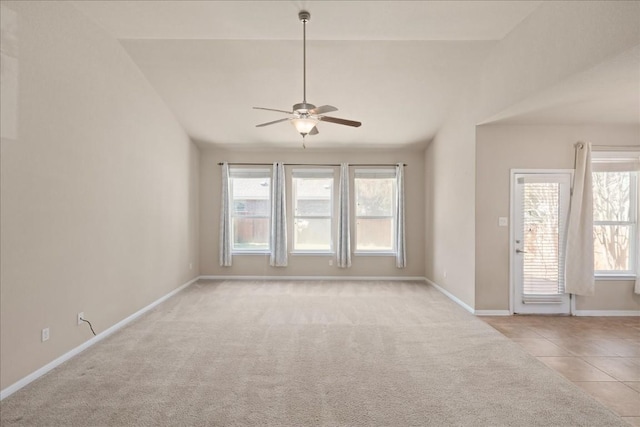 unfurnished room with lofted ceiling, a wealth of natural light, ceiling fan, and light tile patterned floors