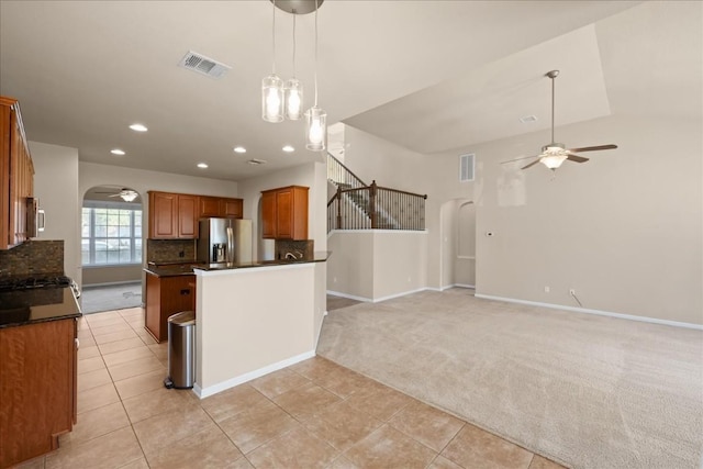 kitchen featuring light carpet, appliances with stainless steel finishes, tasteful backsplash, ceiling fan, and pendant lighting