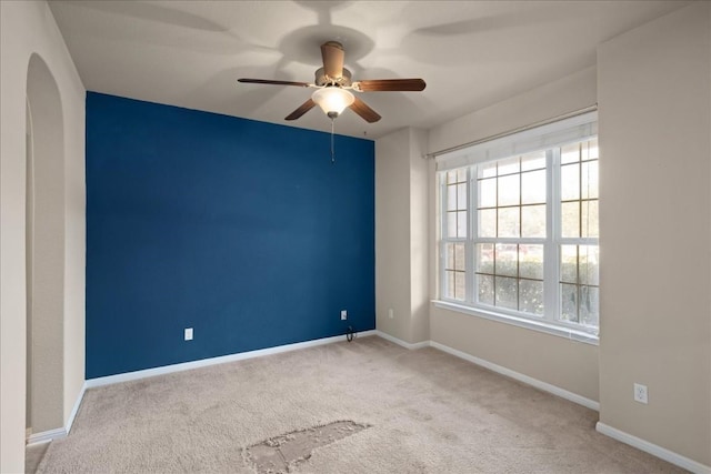 carpeted spare room featuring ceiling fan