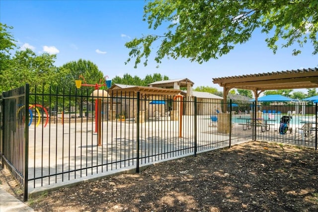 view of gate with fence and a community pool