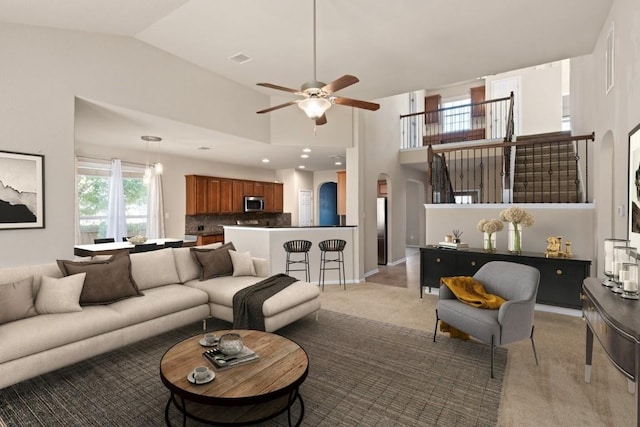 living room with arched walkways, light colored carpet, visible vents, a ceiling fan, and high vaulted ceiling