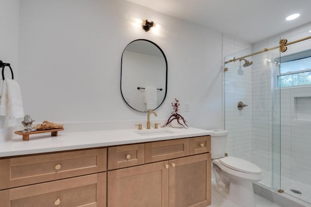 bathroom featuring vanity, toilet, and a shower with door