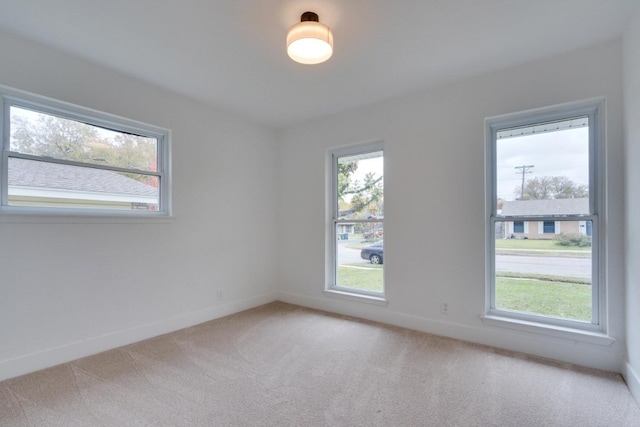 empty room featuring light carpet and plenty of natural light