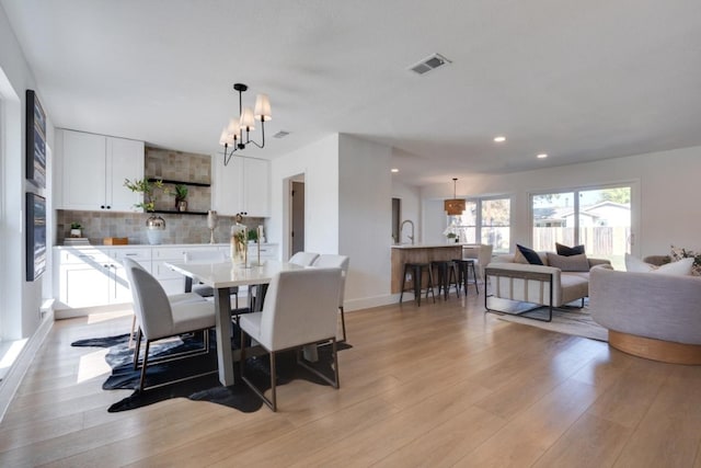 dining area featuring light wood-type flooring and a chandelier