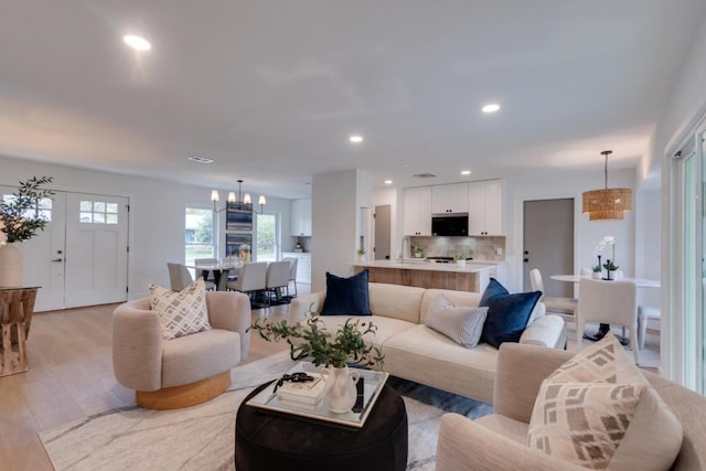 living room featuring light wood-type flooring and an inviting chandelier