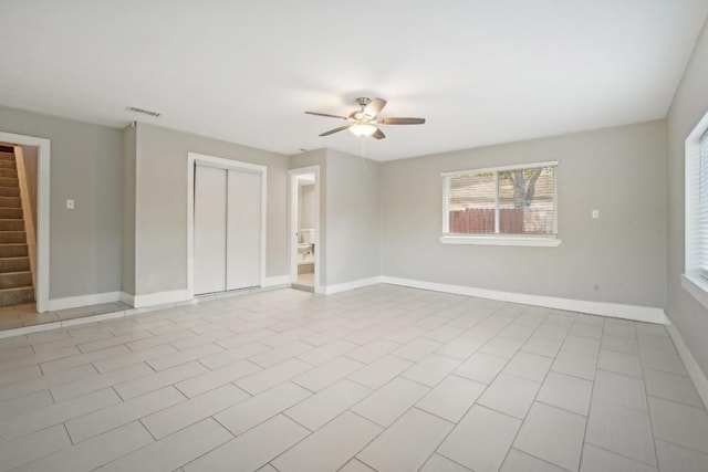 empty room with ceiling fan and light tile patterned floors