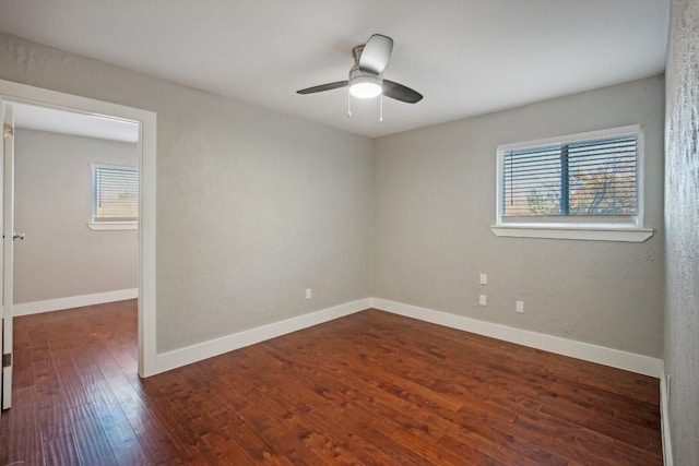 empty room with ceiling fan and dark hardwood / wood-style floors