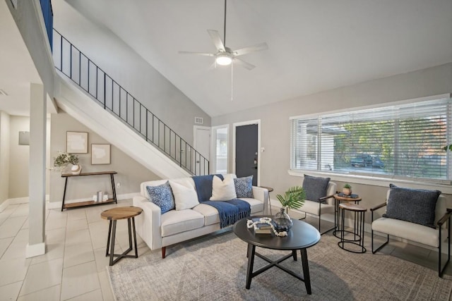 tiled living room with ceiling fan and high vaulted ceiling