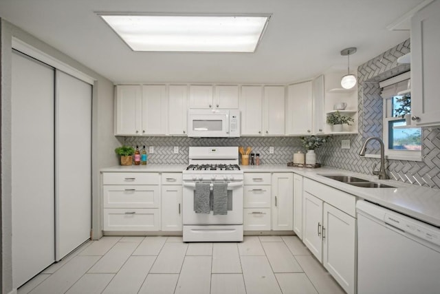 kitchen featuring sink, tasteful backsplash, decorative light fixtures, white appliances, and white cabinets