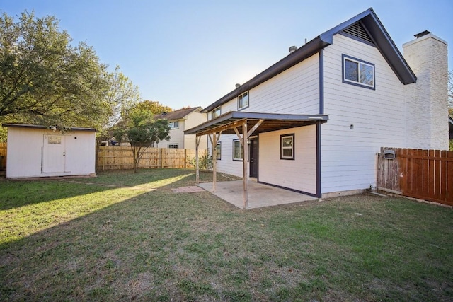 rear view of property with a storage unit, a patio area, and a yard