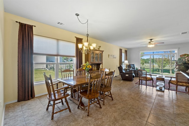 tiled dining area featuring ceiling fan with notable chandelier