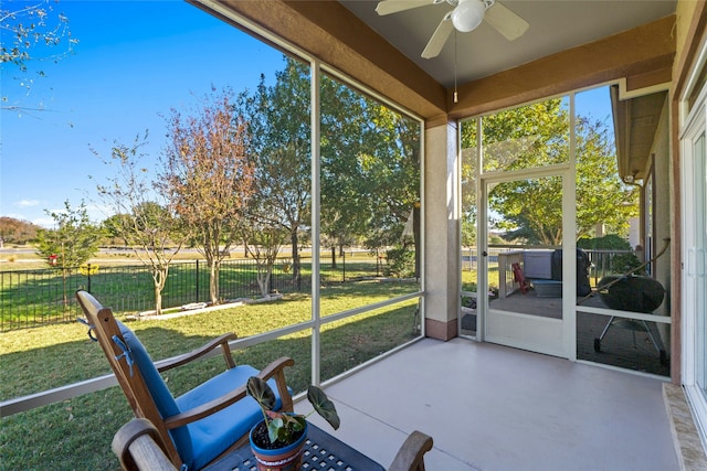 unfurnished sunroom featuring ceiling fan and a wealth of natural light