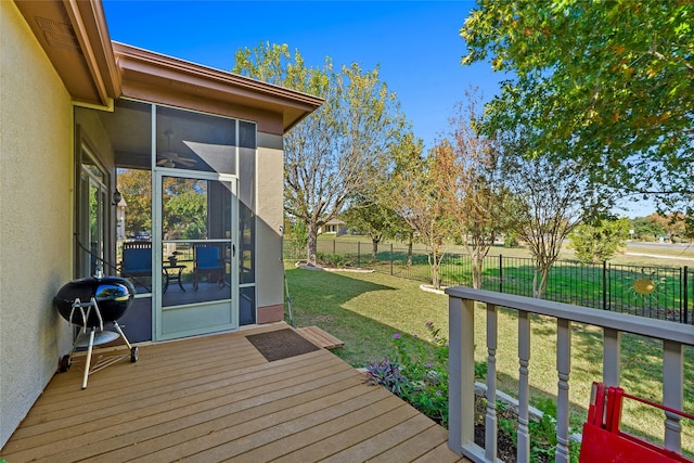 wooden deck with grilling area, a lawn, and a sunroom