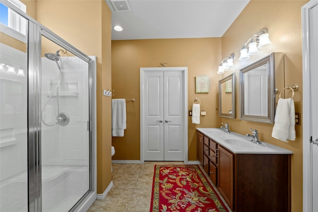 bathroom with tile patterned flooring, an enclosed shower, vanity, and toilet