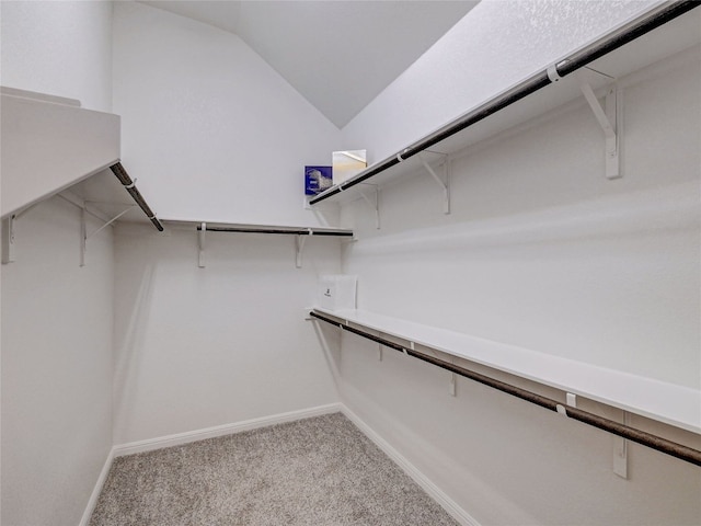 spacious closet featuring light colored carpet and lofted ceiling