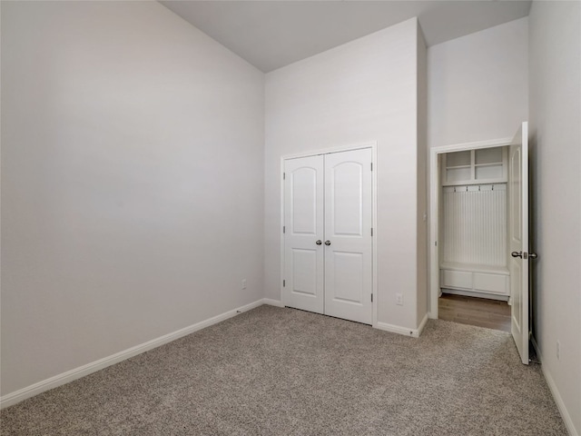 unfurnished bedroom featuring light carpet and a closet