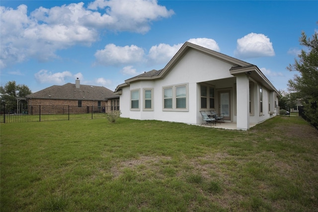 rear view of property featuring a yard and a patio