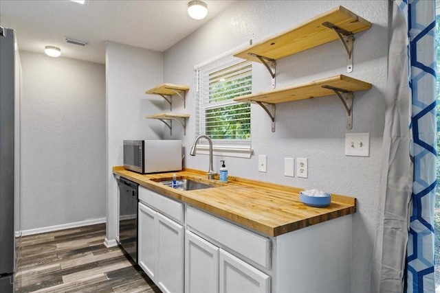 kitchen with dishwasher, butcher block counters, sink, dark hardwood / wood-style flooring, and white cabinetry