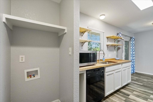 kitchen featuring light wood-type flooring, sink, white cabinets, black dishwasher, and butcher block counters