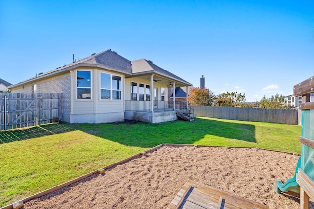 rear view of property with a lawn and ceiling fan