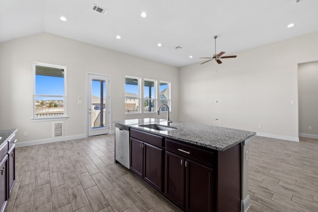 kitchen with dishwasher, a kitchen island with sink, sink, light wood-type flooring, and light stone counters