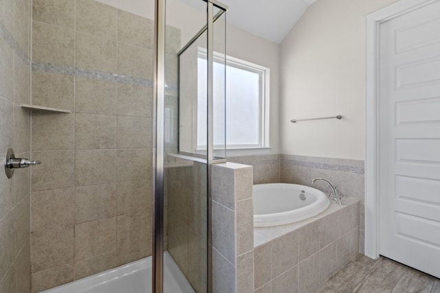 bathroom with plus walk in shower, hardwood / wood-style floors, and vaulted ceiling