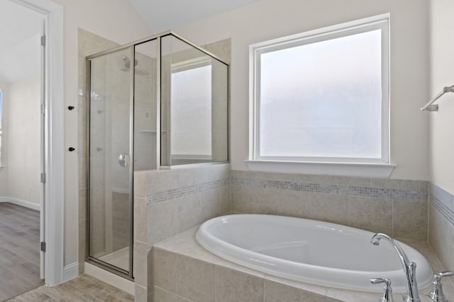 bathroom with hardwood / wood-style flooring, independent shower and bath, and vaulted ceiling