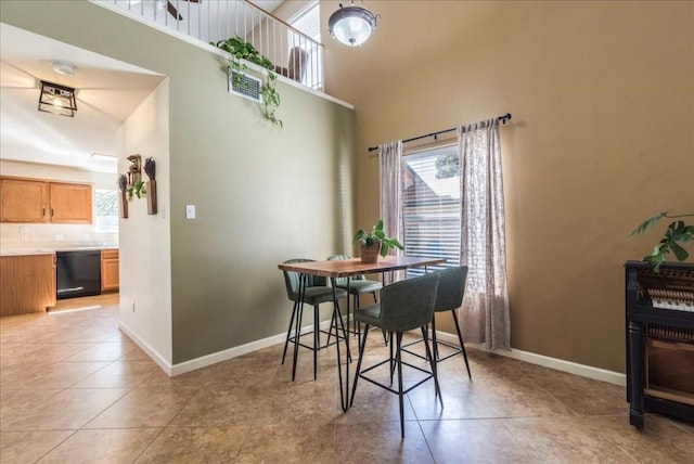 dining space featuring light tile patterned floors and lofted ceiling