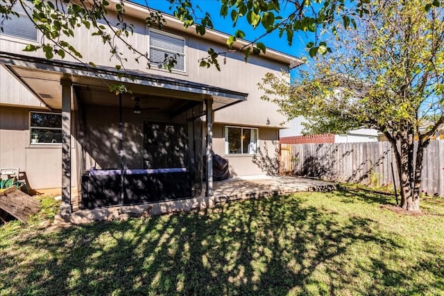 back of property with a yard and a patio