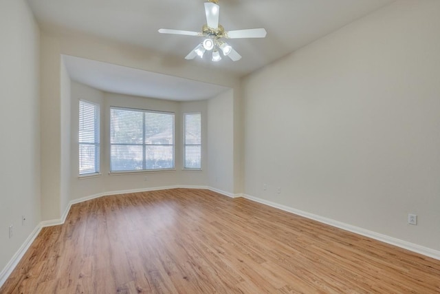 empty room with ceiling fan and light hardwood / wood-style floors