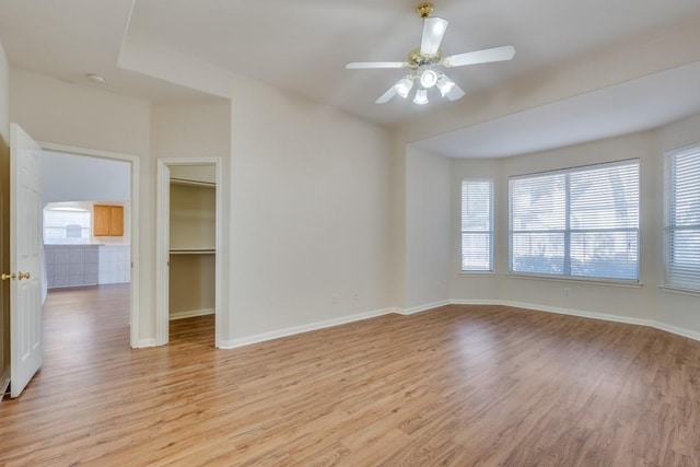 empty room with light hardwood / wood-style flooring and ceiling fan