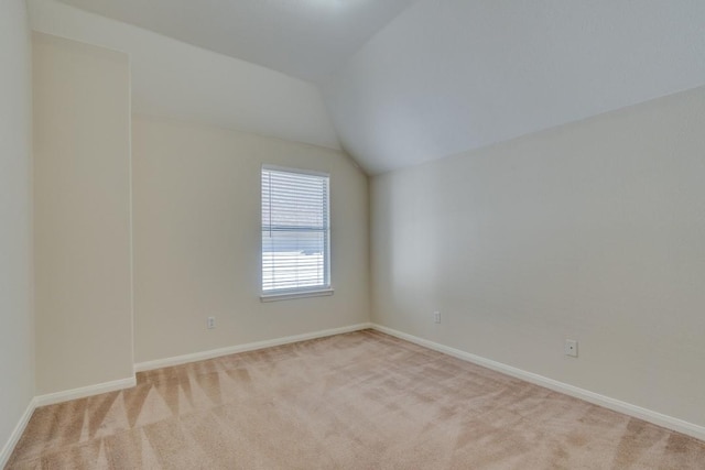 bonus room with light colored carpet and vaulted ceiling