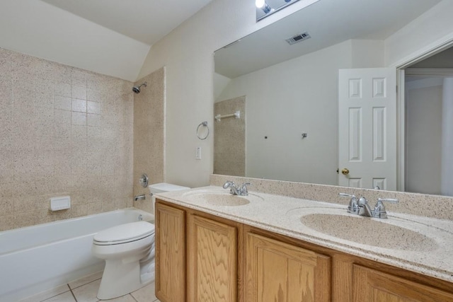 full bathroom with tiled shower / bath combo, tile patterned floors, vaulted ceiling, toilet, and vanity