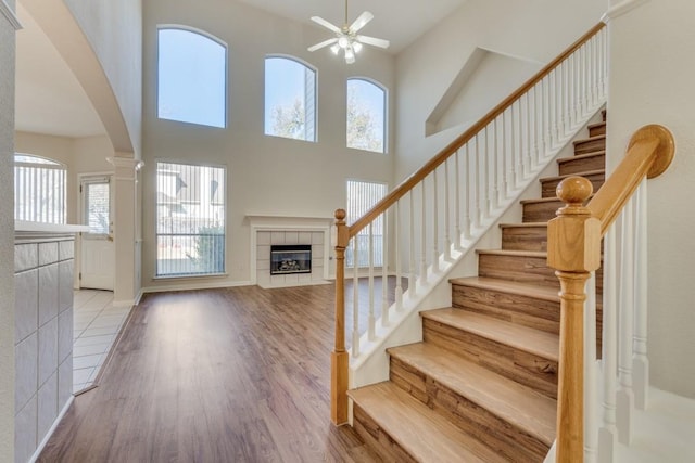 stairway with hardwood / wood-style floors, a towering ceiling, and a wealth of natural light