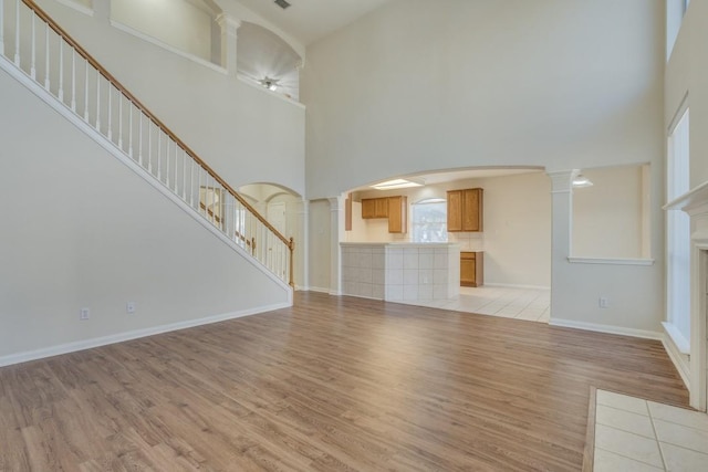 unfurnished living room featuring a high ceiling and light wood-type flooring