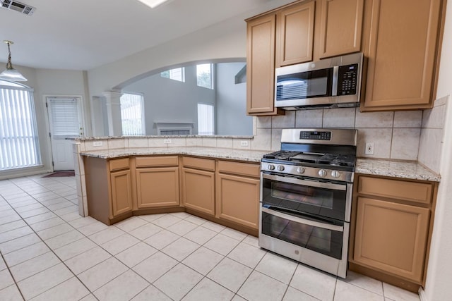 712 Runners Rdg, Pflugerville, TX 78660 - kitchen featuring appliances with stainless steel finishes, arched walkways, a peninsula, backsplash, and ornate columns