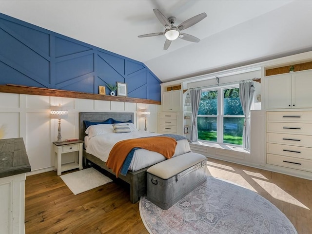 bedroom with ceiling fan, dark wood-type flooring, and vaulted ceiling